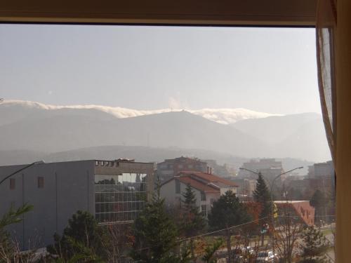a view of snow covered mountains from a window at Hotel Konti in Korçë
