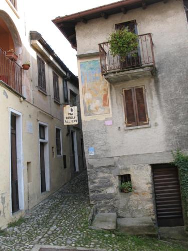 an old building with a balcony on a street at Locanda del Pittore in Arcumeggia