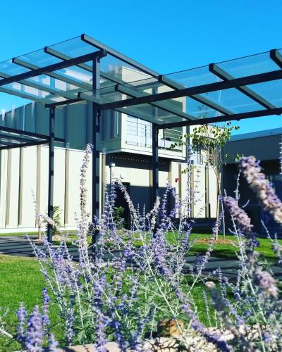a building with purple flowers in front of it at Hotel Libera Caen Colombelles in Caen