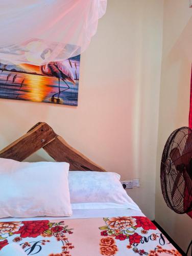 a bedroom with a bed and a painting on the wall at Eagle Nest lake Natron Lodge in Mtowabaga