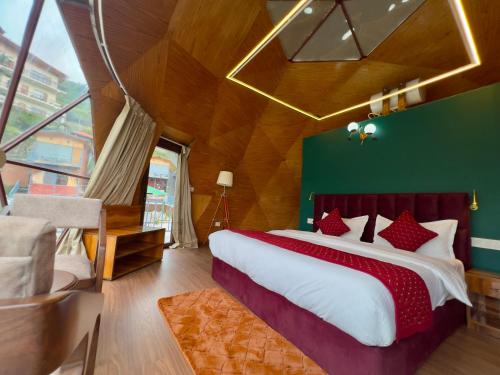 a bedroom with a large bed and a green wall at The host in Kanatal