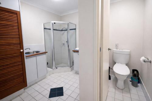 a white bathroom with a shower and a toilet at Scarborough Beach Front Resort - Shell Seven in Perth