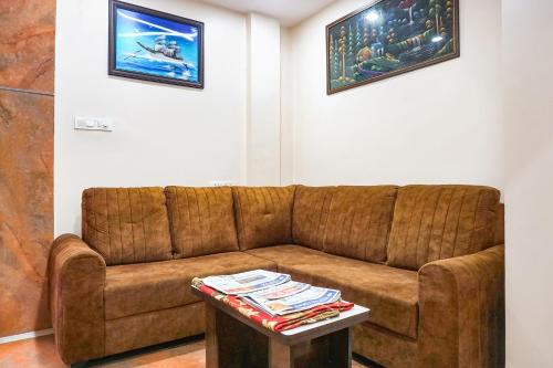 a brown couch in a living room with a table at FabHotel Rachana Residency - Nr Shivaji Nagar Metro Station in Pune