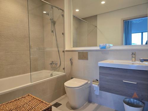 a bathroom with a toilet and a sink and a shower at Ark Living Stay in Yas Island in Yas Island