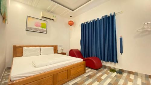 a bedroom with a bed and a red chair at Nhật Minh Hotel in Thuan An