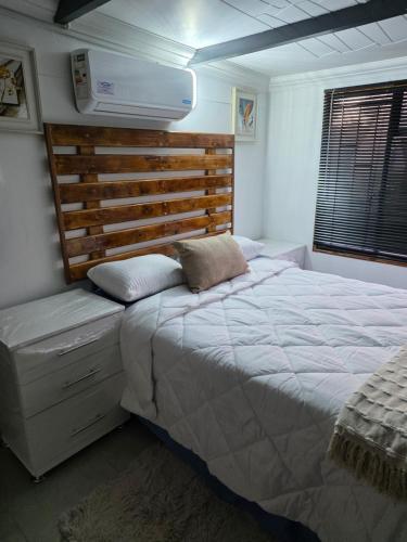 a bedroom with a large bed with a wooden headboard at CLP Lodge in Bela-Bela