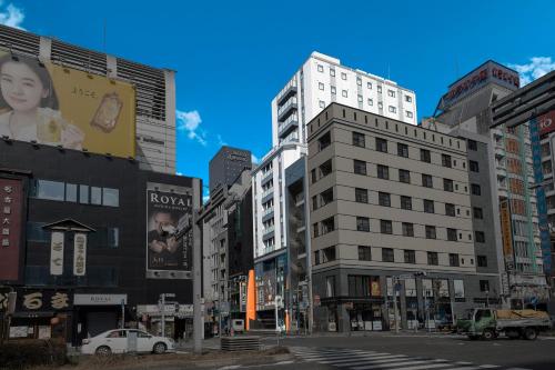 a city street with tall buildings on a sunny at Hotel Actel Nagoya Nishiki in Nagoya