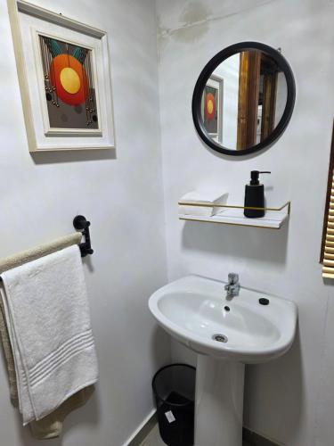 a white bathroom with a sink and a mirror at CLP Lodge in Bela-Bela