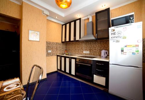 モスクワにあるBakuleva 6 Apartmentの青のフロアのキッチン(白い冷蔵庫付)