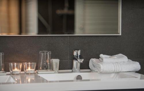 ein Waschbecken mit Handtüchern und Gläsern darauf in der Unterkunft Hotel Hippocampus in Mol