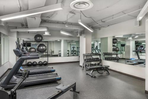 a gym with several treadmills and machines in it at The Quincy, an Ascend Collection Hotel in Washington, D.C.