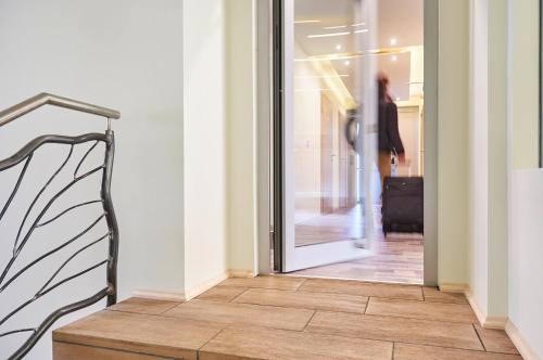 a person walking into a store through a glass door at Auenwald Hotel und Apartmenthaus in Leipzig