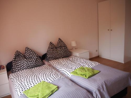 een slaapkamer met 2 bedden en kussens bij Apartament DOMINO in Karpacz