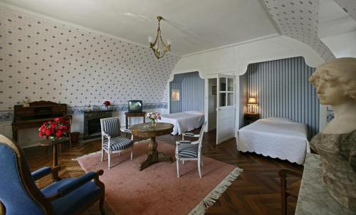 um quarto com uma cama e uma mesa com cadeiras em Hostellerie de la Commanderie em Condat-sur-Vézère