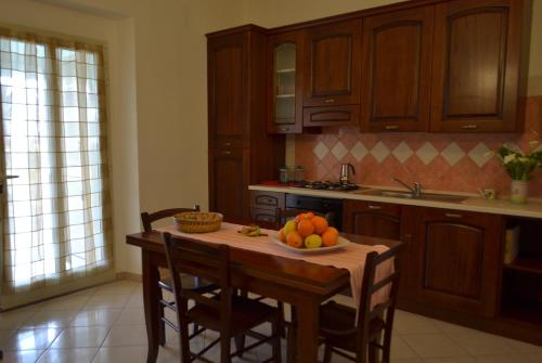 a kitchen with a table with a bowl of fruit on it at Le Mimose in Cala Liberotto