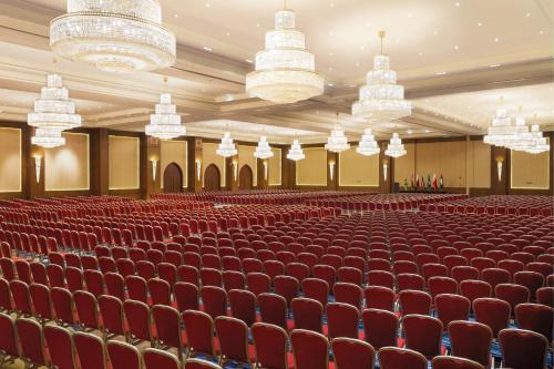 an empty auditorium with red chairs and chandeliers at InterContinental Durrat Al Riyadh Resort & Spa by IHG in Riyadh