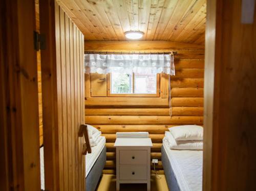 a small room with two beds and a window at Eetuntupa in Keuruu
