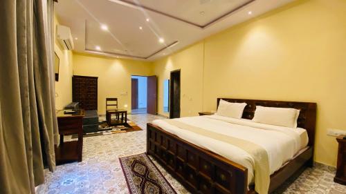 a bedroom with a bed and a desk and a television at The Byke - The Sanctuary Heritage - Pan India Pure Veg Hotel Chain in Kumbhalgarh