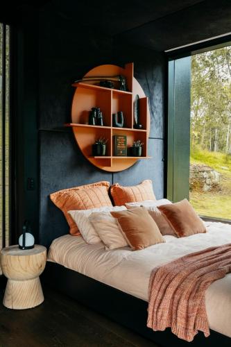 a bedroom with a large bed with an orange shelf at The Lantern - a Huch experience in Wollombi