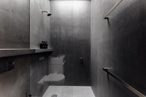 a bathroom with a toilet and a glass shower at The Lantern - a Huch experience in Wollombi