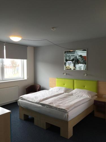 a bedroom with a bed and a tv on the wall at Sport hotel Sletiště in Kladno