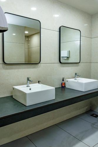 a bathroom with two sinks and a mirror at Hotel Lals Residency, Adoor in Adūr