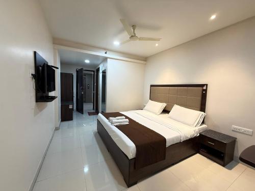 a bedroom with a bed and a flat screen tv at Hotel Center Point in Bhubaneshwar