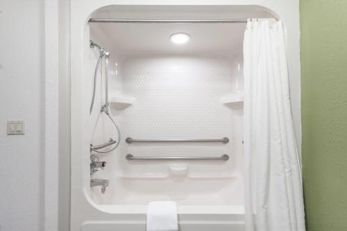 a bathroom with a shower with a shower curtain at Baymont by Wyndham Pueblo in Pueblo