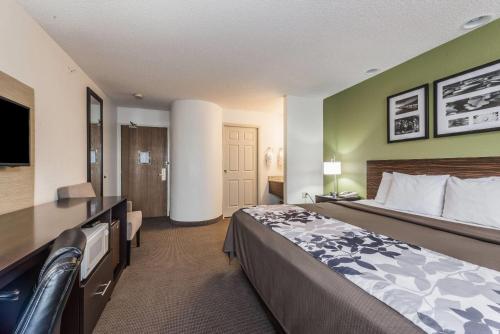 a hotel room with a bed and a flat screen tv at Baymont by Wyndham Pueblo in Pueblo