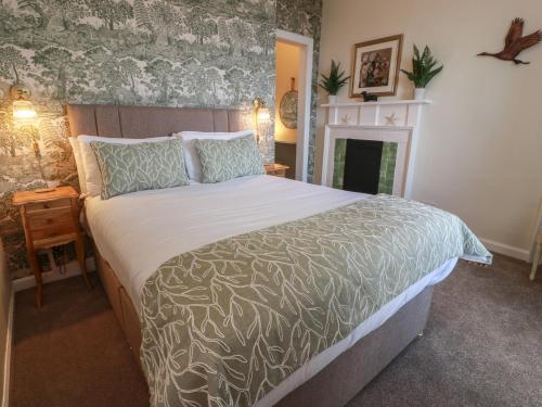 a bedroom with a large bed and a fireplace at North Segganwell - Culzean Castle in Maybole