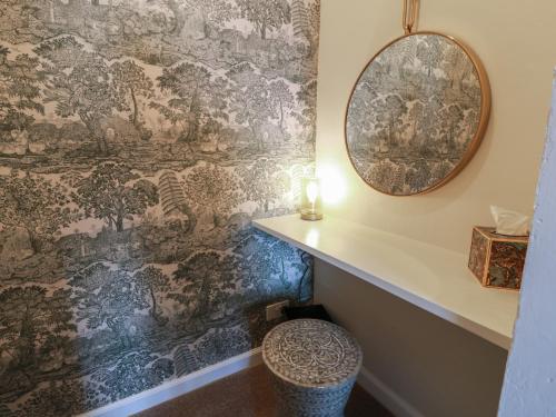 a bathroom with a wallpaper with a stool and a mirror at North Segganwell - Culzean Castle in Maybole