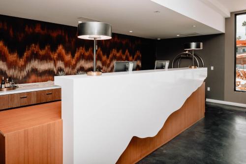 a bar in a restaurant with a white counter at V Capri Palm Springs, a Dolce by Wyndham in Palm Springs