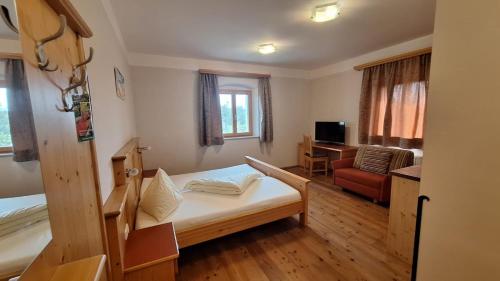 a room with a bed and a couch and a desk at Waldbothgut in Linz