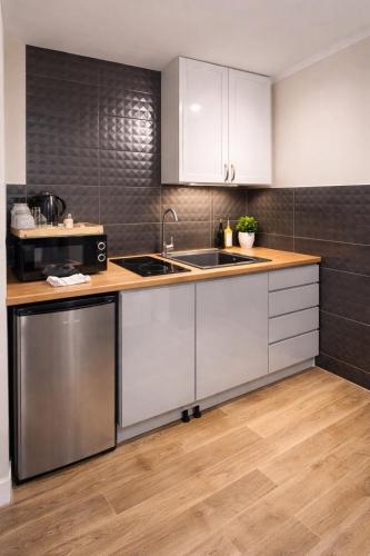 a kitchen with white cabinets and a sink at studio Szymanowskiego 5 in Szczecin