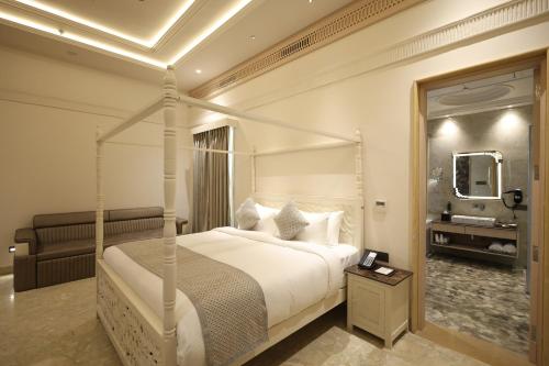 a bedroom with a canopy bed and a bathroom at The Surya Golden Palace, Pushkar in Pushkar
