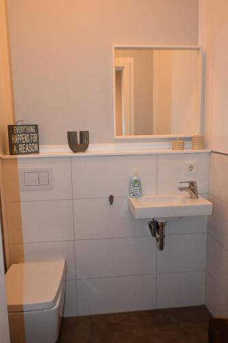 a bathroom with a sink and a mirror and a toilet at Heimathaven 2 in Bremerhaven