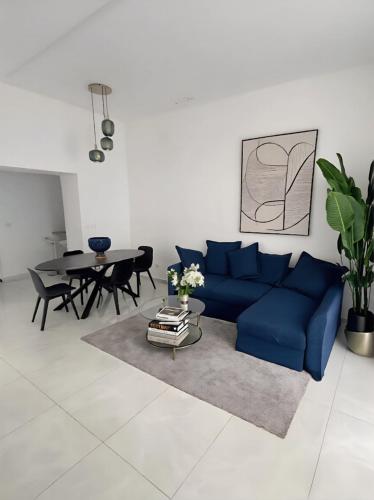 a living room with a blue couch and a table at Aura - Luxury Suite in Syracuse