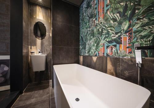 a bathroom with a large white tub and a sink at Myeongdong Chungmuro Youngin Hotel in Seoul
