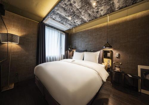 a large white bed in a room with a window at Myeongdong Chungmuro Youngin Hotel in Seoul