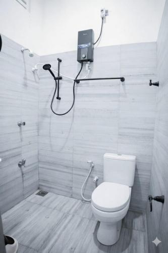 a bathroom with a toilet and a shower at Walker's Residency in Anuradhapura