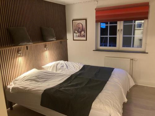 a bedroom with a large bed with a window at Hegedal Fjordhouse in Hobro