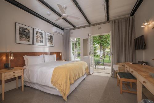 a bedroom with a large bed and a desk at Graskop Hotel in Graskop
