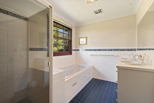 a bathroom with a tub and a sink and a shower at Chestnut Tree Farm in Werai