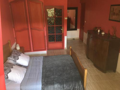 a room with a bed and a red door at Chambre d'Hotes La Brunetière in Gréoux-les-Bains