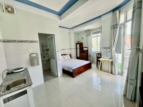 a bathroom with a bed and a sink in a room at NGỌC QUÝ Mini House in Quy Nhon