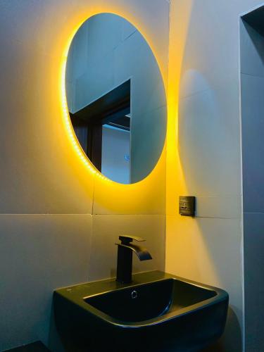 a bathroom with a black sink and a mirror at TGH Gracies Hotel in Port Harcourt