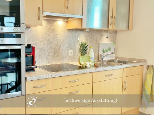 a kitchen with a sink and a stove at Ferienwohnung de Lark Penthouse mit Nordseeblick in Dorum-Neufeld