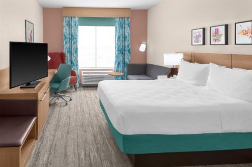a hotel room with a bed and a television at Hilton Garden Inn Topeka in Topeka