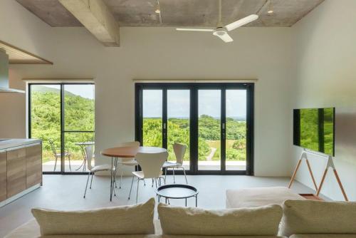 a living room with a couch and a table and chairs at Palm Hills in Ishigaki Island