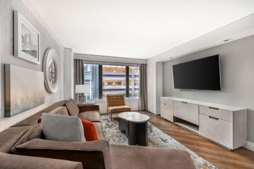 a living room with a couch and a tv at Hilton Grand Vacations Club Chicago Magnificent Mile in Chicago